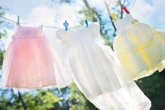 Kinderkleider hängen an einer Wäscheleine.